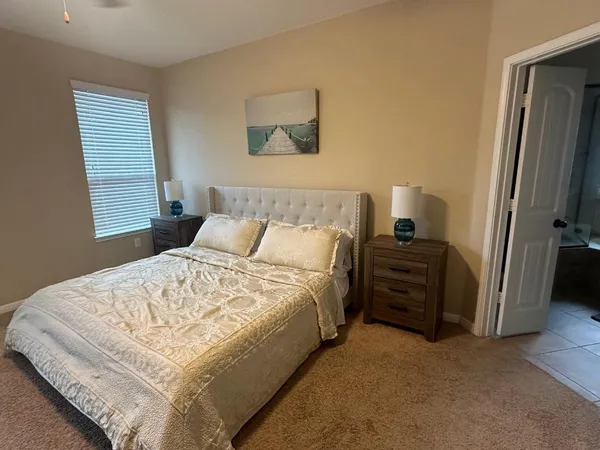 a bed sitting in a bedroom next to a window