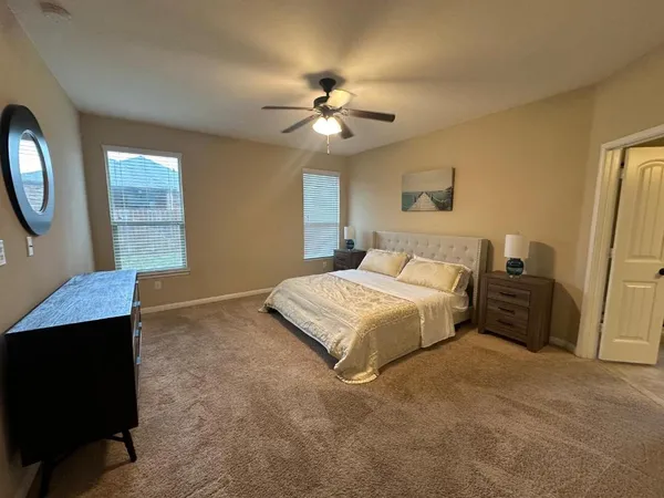 a bedroom with a large bed and a chandelier