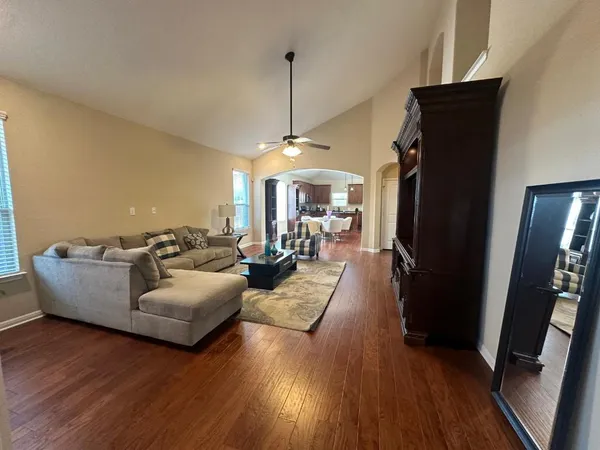 a kitchen with a refrigerator a stove a sink dishwasher a oven with wooden cabinets and wooden floor