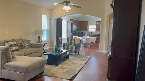 a living room with furniture and a chandelier