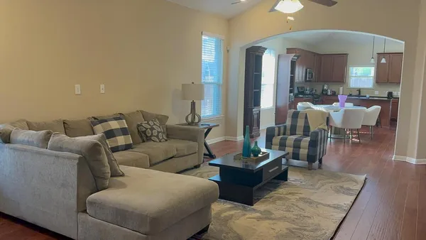 a living room with furniture and a chandelier