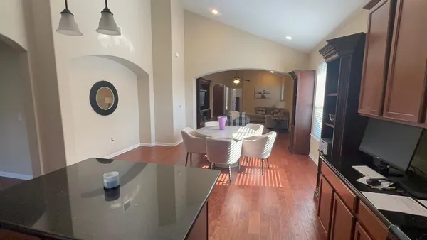 a living room with furniture hard wood floor and a flat screen tv