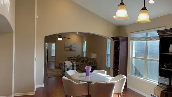 a dining room with furniture and wooden floor