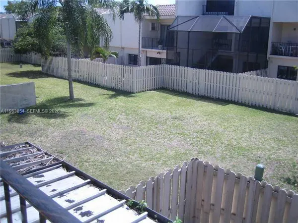a view of a backyard with a wooden fence