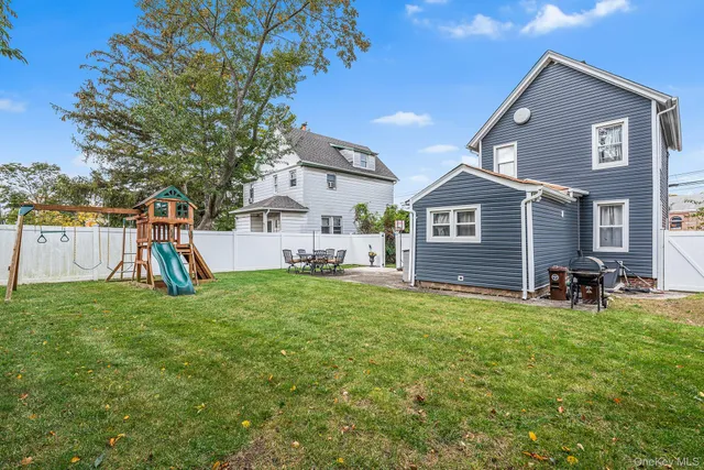 a view of a house with backyard and a tree
