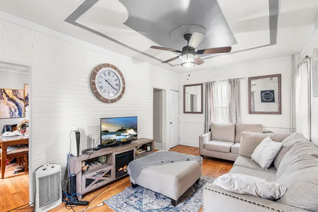 a living room with furniture a flat screen tv and a wall clock