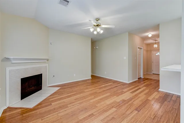 a view of empty room with wooden floor and fireplace