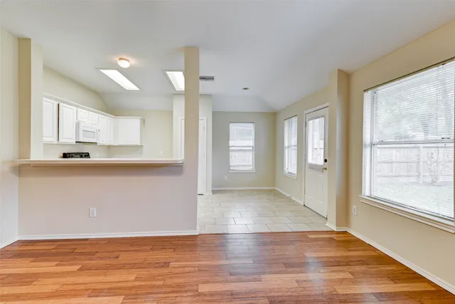 a view of a kitchen with wooden floor and a window