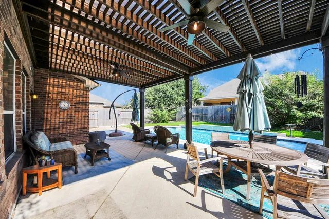 a view of a patio with table and chairs potted plants with wooden floor and fence