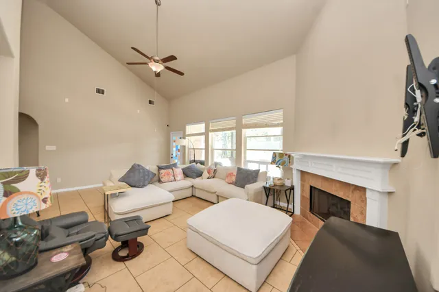 a living room with furniture a fireplace and a flat screen tv
