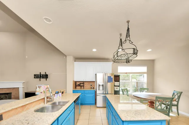 a dining room with wooden floor a chandelier a wooden table and chairs
