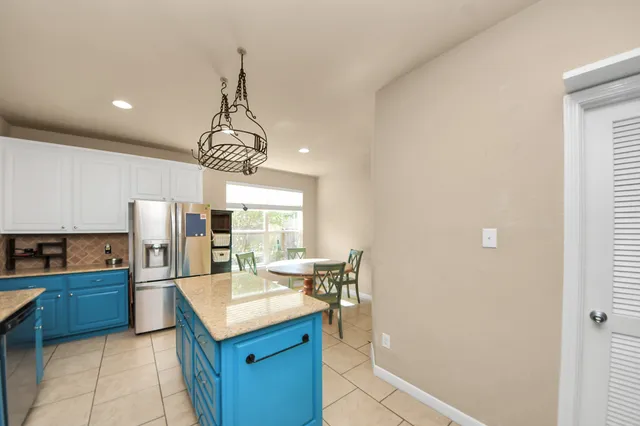 a kitchen with stainless steel appliances granite countertop a sink and a refrigerator