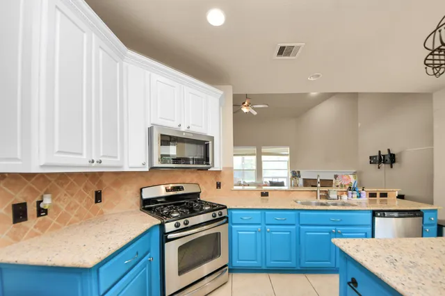 a kitchen with stainless steel appliances granite countertop a stove a sink and a microwave