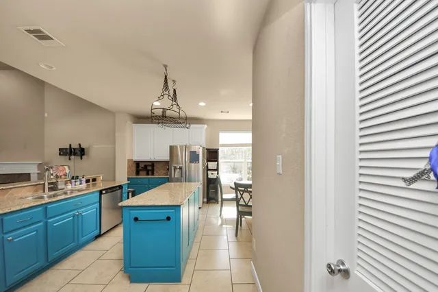 a large kitchen with a lot of counter space and a refrigerator