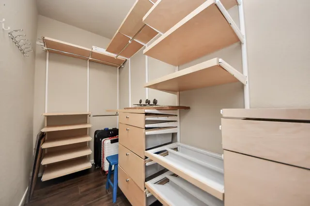 a view of an empty room with stairs and wooden floor