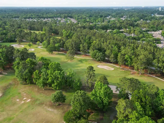 an aerial view of residential houses with outdoor space and trees