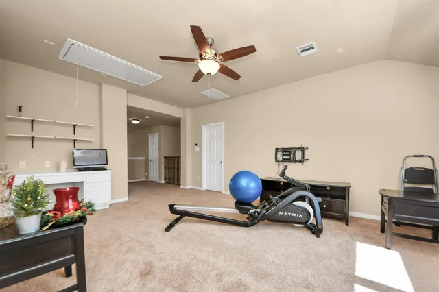 a view of a workspace with furniture and a ceiling fan