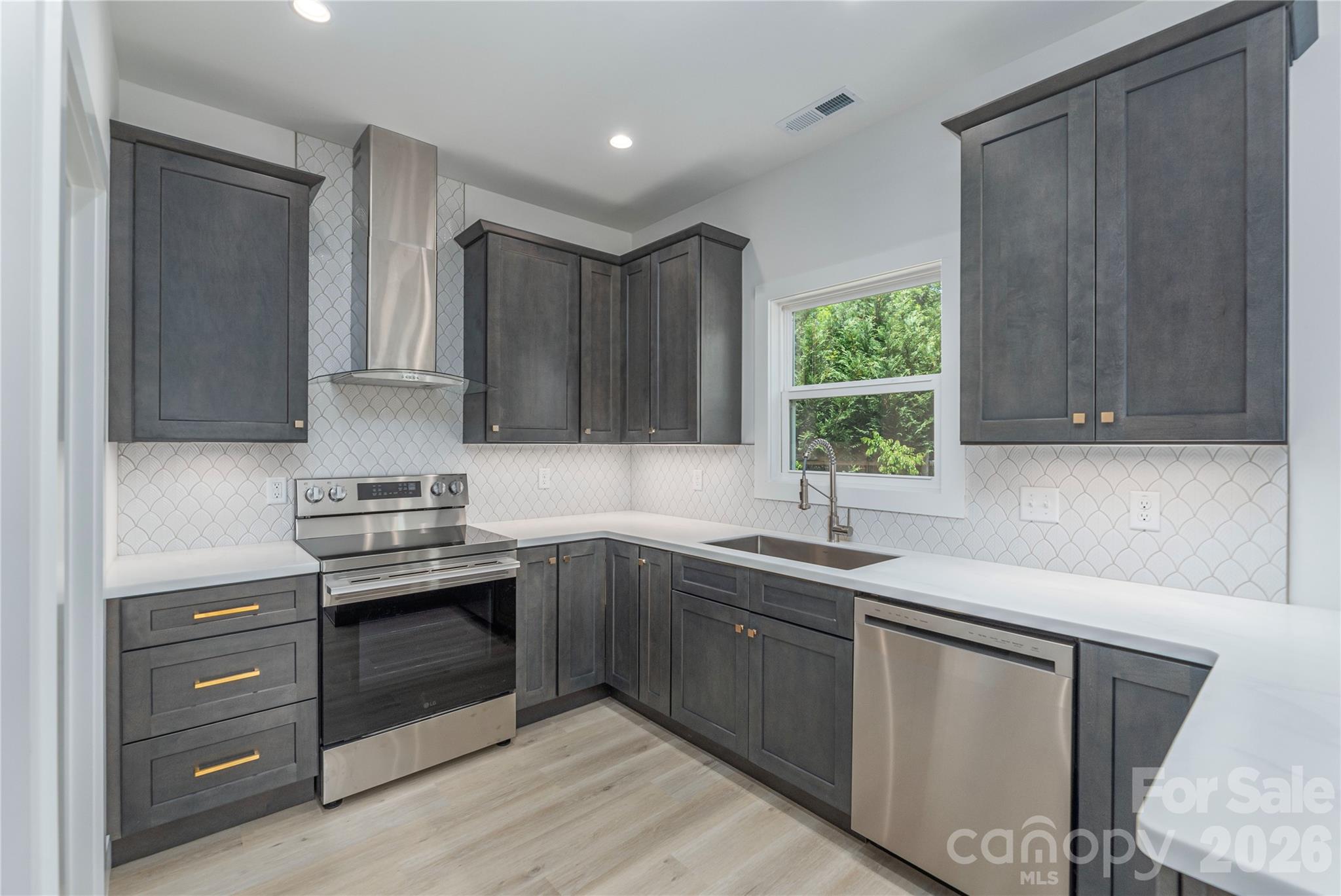 32 Oak Hill Road Candler, NC 28715 - Photo 11 of 29 a kitchen with stainless steel appliances granite countertop a sink stove and cabinets