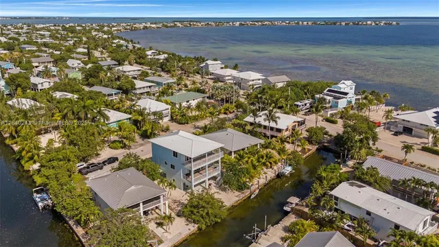 a view of a bedroom with a bed and wooden floor