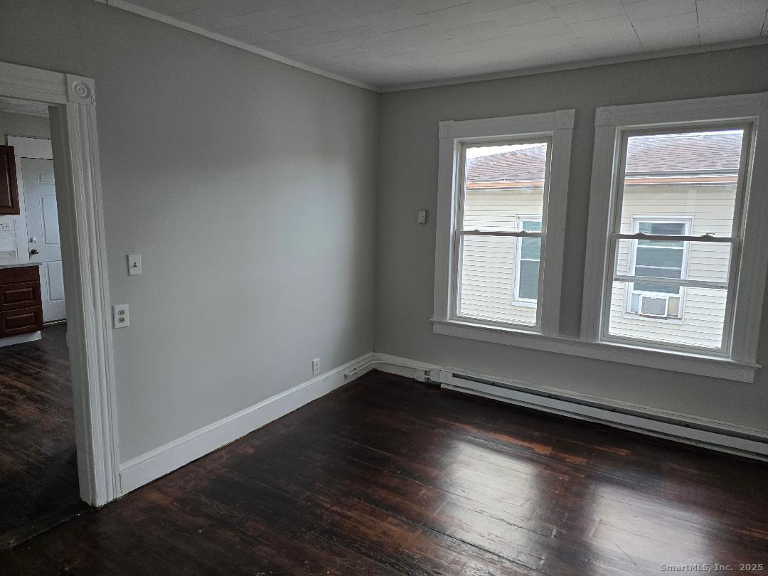 133 South Street, Unit 3 Waterbury, CT 06706 - Photo 2 of 4 an empty room with wooden floor and windows