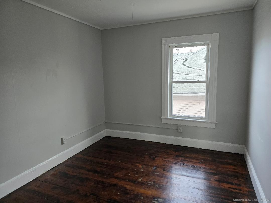 133 South Street, Unit 3 Waterbury, CT 06706 - Photo 3 of 4 an empty room with wooden floor and windows