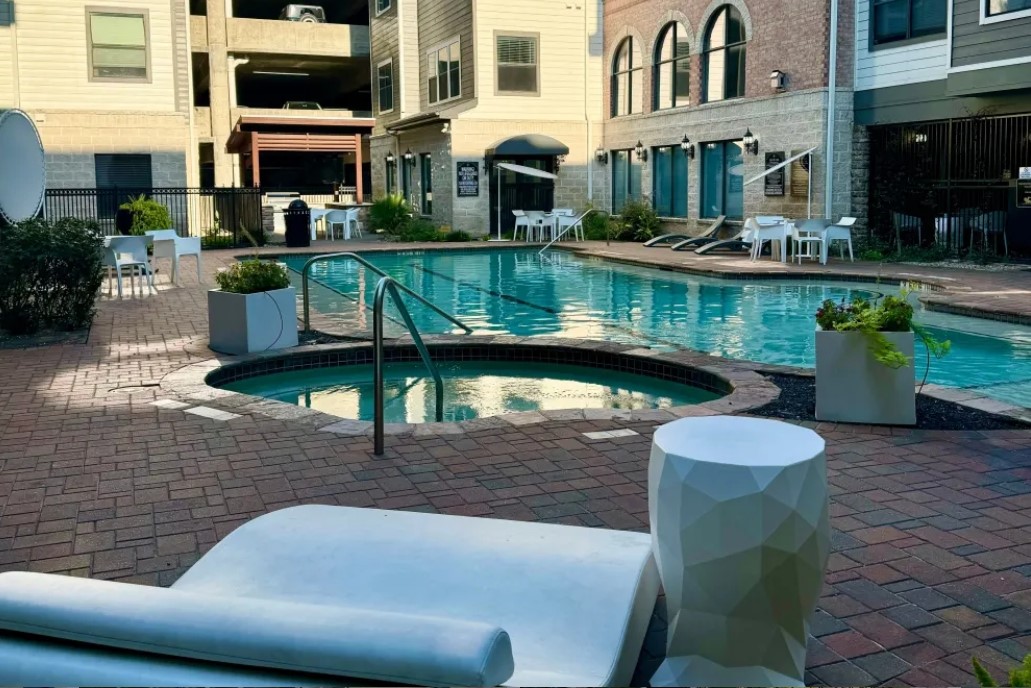 a patio with table and chairs potted plants