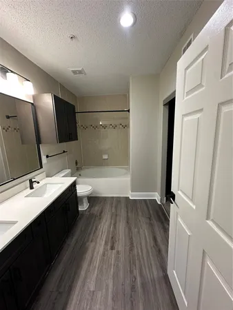 a bathroom with a sink a toilet a mirror and shower