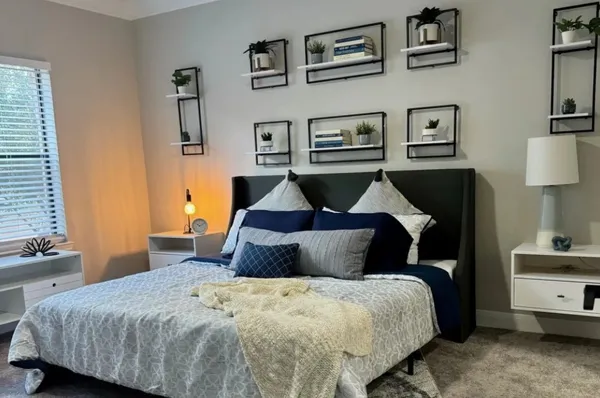 a bedroom with a bed and painting on the wall