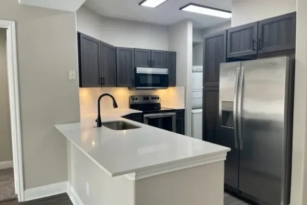 a kitchen with refrigerator and a sink