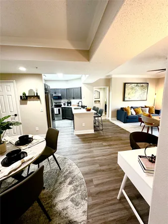a living room with furniture and a dining table with kitchen view