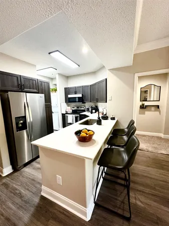 a kitchen with stainless steel appliances a stove a sink a refrigerator and cabinets