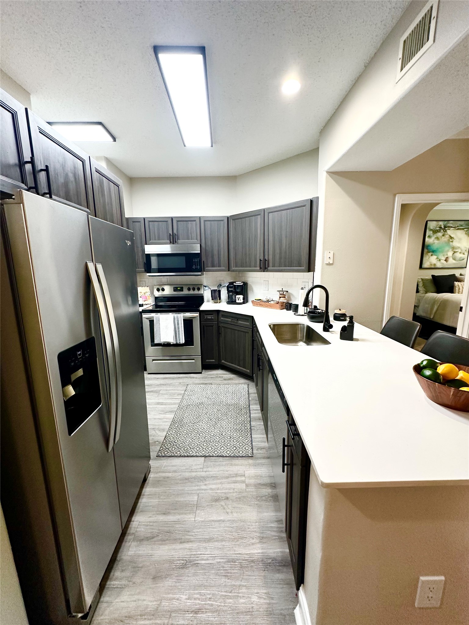 2345 Sage Road, Unit 143 Houston, TX 77056 - Photo 8 of 19 a kitchen with stainless steel appliances a refrigerator sink and microwave