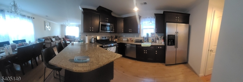 944 Flora Street Elizabeth, NJ 07201 - Photo 4 of 19 a kitchen with stainless steel appliances granite countertop a sink a stove a refrigerator a microwave a dining table and chairs