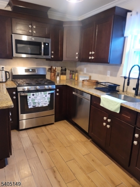944 Flora Street Elizabeth, NJ 07201 - Photo 5 of 19 a kitchen with stainless steel appliances granite countertop a stove a sink and a microwave