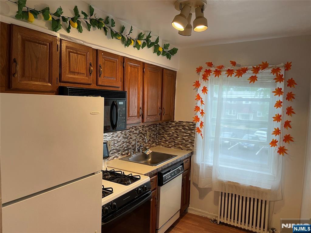 245 Passaic Avenue, Unit B4 Passaic, NJ 07055 - Photo 7 of 13 a kitchen with granite countertop a stove and a refrigerator