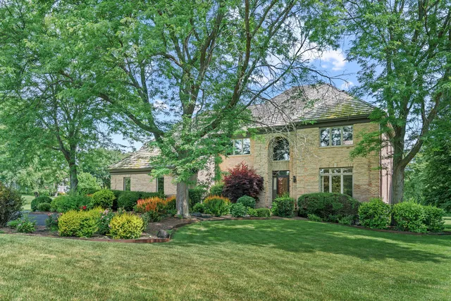 a front view of a house with a yard and potted plants