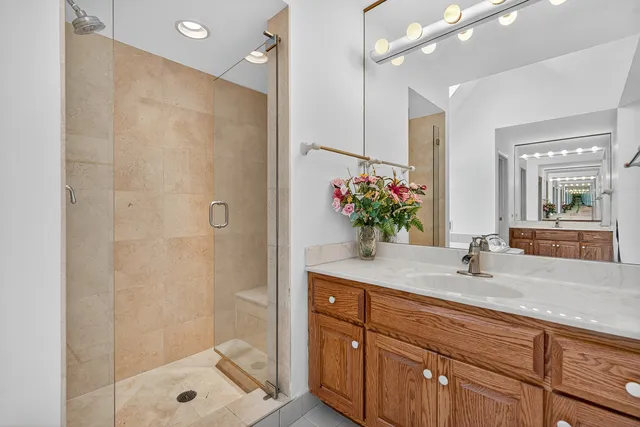 a bathroom with a shower sink vanity and mirror