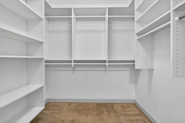 a view of walk in closet with empty racks