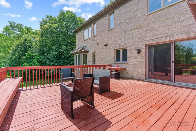 a balcony with wooden floor table and chairs