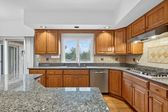 a kitchen with stainless steel appliances granite countertop a stove sink and cabinets