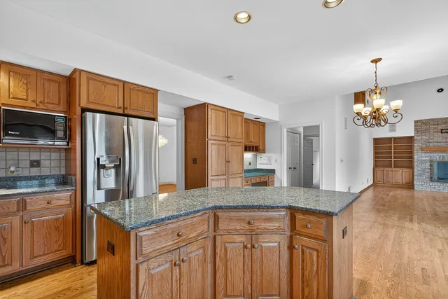 a kitchen with granite countertop a refrigerator a stove and a sink