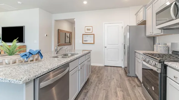 a kitchen with granite countertop a sink stove and refrigerator