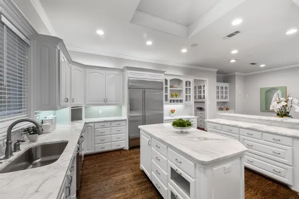a open dining room with furniture a kitchen and chandelier