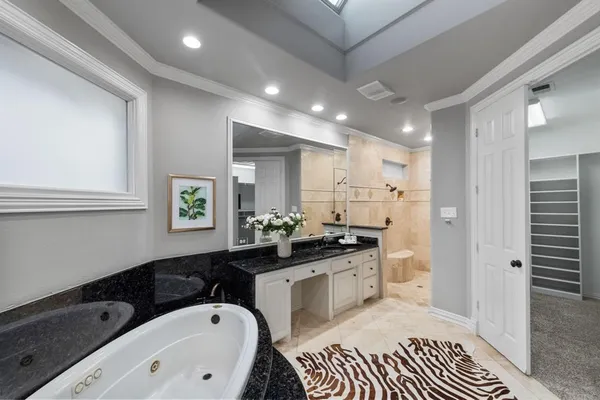 a bathroom with a granite countertop sink mirror and bathtub