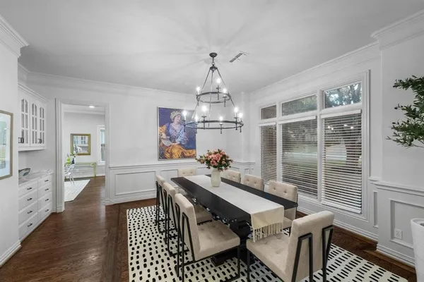 a dining room with furniture a chandelier and wooden floor