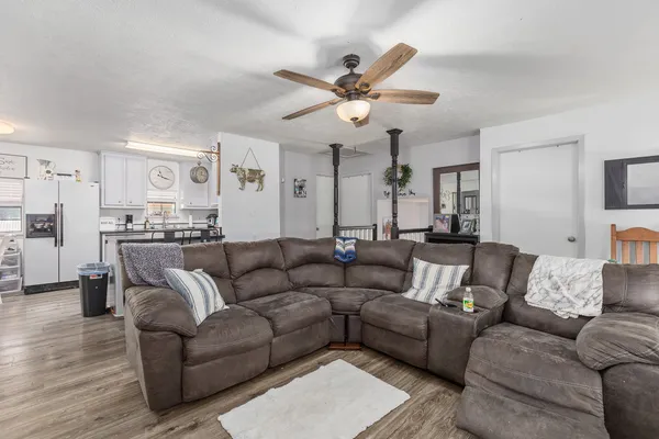 a kitchen with stainless steel appliances granite countertop a sink dishwasher a stove a refrigerator a dining table and chairs with wooden floor