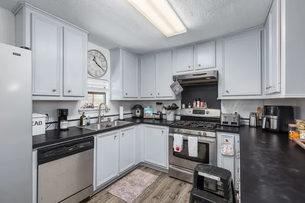a kitchen with stainless steel appliances granite countertop a stove and cabinets