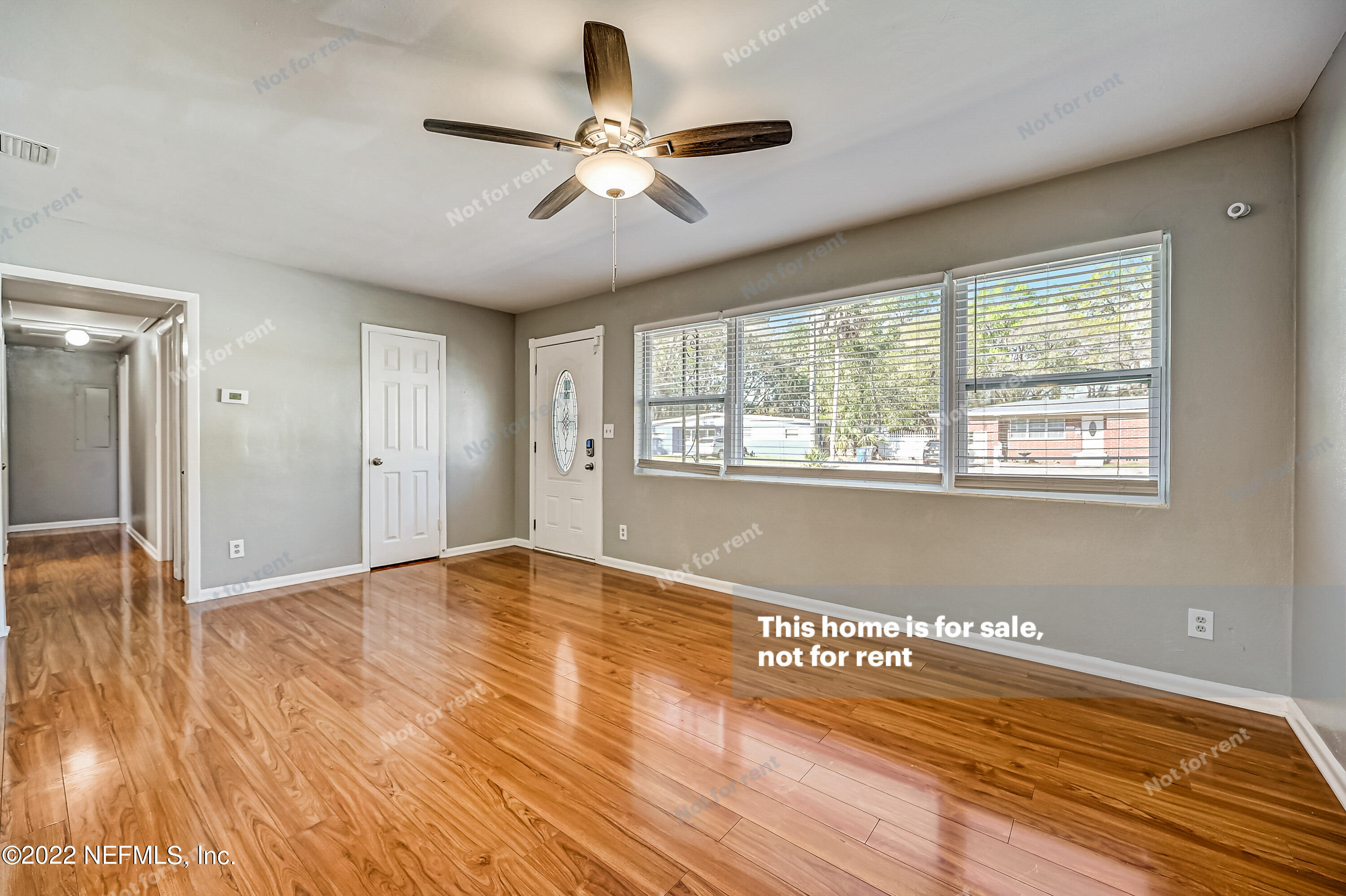 3383 Rogero Road Jacksonville, FL 32277 - Photo 19 of 29 a view of an empty room with wooden floor and a window