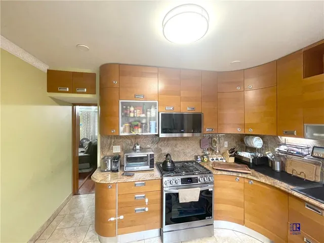 a kitchen with stainless steel appliances granite countertop a stove a sink and a refrigerator