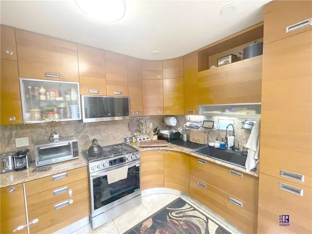 a kitchen with stainless steel appliances a sink a stove and a refrigerator